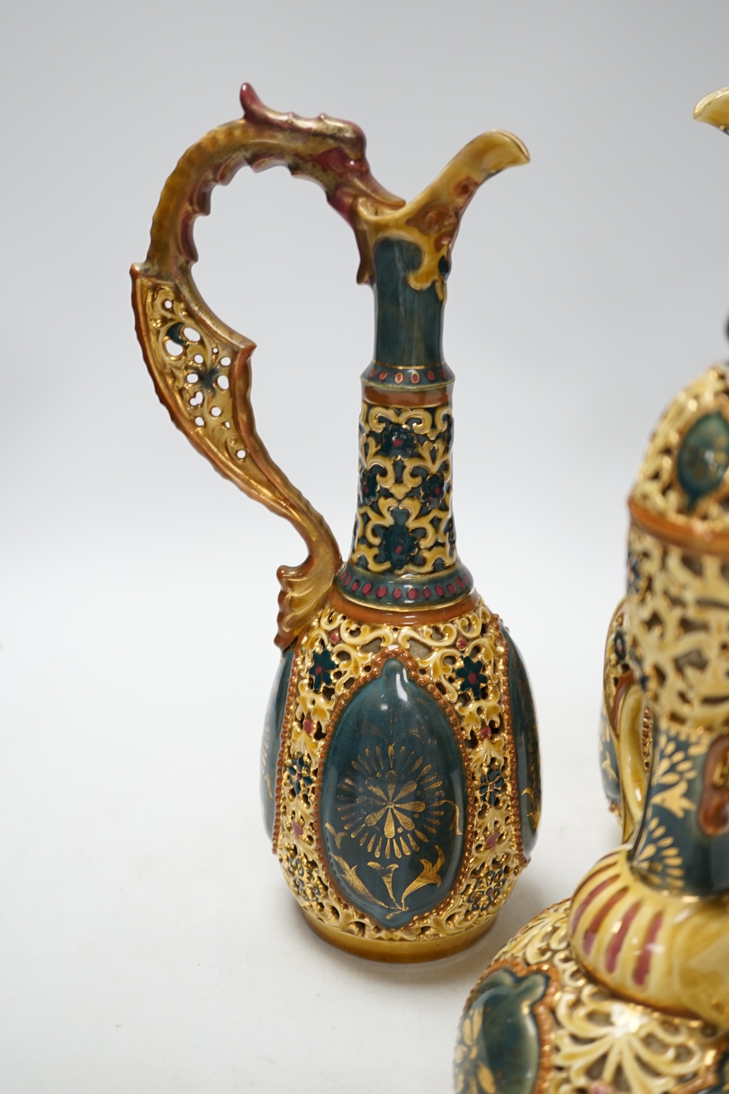 A pair of Zsolnay ewers and a similar ewer with cover, tallest 30cm high